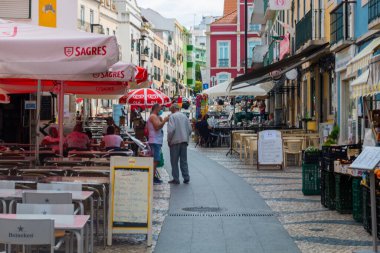 Lizbon 'un en popüler mahallelerinden biri olan Almada' da günlük yaşam. Nehrin üzerinde ve küçük bir köy gibi. Restoranlar, insanlar var ve Portekiz 'de hayat ve renklerle dolu.