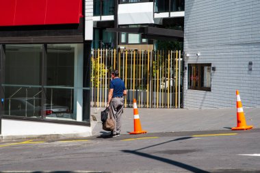 İnsanlar günlük yaşamlarını Auckland şehir merkezinde (Yeni Zelanda), bir yaz günü okyanusun yanında, ana caddelerde geçirirler. Şehir dükkanlar ve gökdelenlerle dolu. Modern bir şehir manzarası.. 