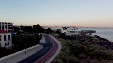 Portekiz 'in Lizbon kentindeki Cascais köyünün gün batımında inanılmaz hava manzarası. Okyanusa yakın bir şehrin manzarası. Denizin panoramik manzarası ve TheBoca do Inferno gibi diğer doğal manzaralar için gelenler..