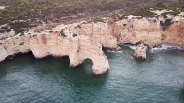 Portekiz 'in güney bölgesindeki kayaların ve uçurumların güzel insansız hava aracı görüntüsü. Algarve, mavi okyanusu ve muhteşem manzaralarıyla Portekiz 'in en turistik ve manzaralı yerlerinden biridir..