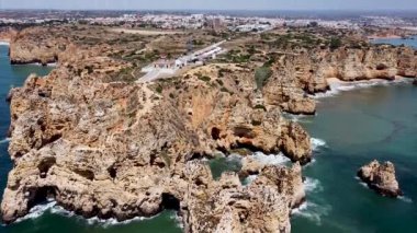 Portekiz 'in güney bölgesindeki kayaların ve uçurumların güzel insansız hava aracı görüntüsü. Algarve, mavi okyanusu ve muhteşem manzaralarıyla Portekiz 'in en turistik ve manzaralı yerlerinden biridir..