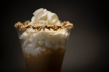 Büyük bardakta lezzetli İtalyan sıcak çikolatası. Üstünde el yapımı krema olan lezzetli bir çikolata büyük süslü bir bardakta çikolatalı İtalyan dondurmasıdır. Hepsinin siyah bir geçmişi var.