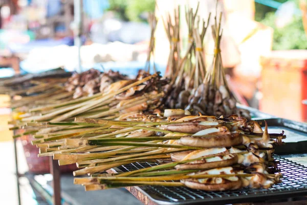 Yaz günü Asya pazarında ızgara kalamarlar gibi ızgara yapıyorlar. Bu yiyecek her zaman tazeydi ve Asya 'nın güneyi sokaklarla dolu.