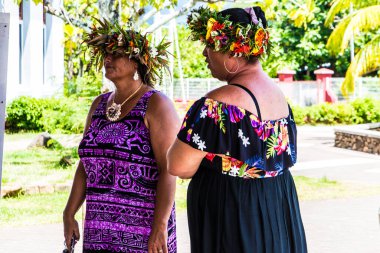 Moorea, Fransız Polinezyası: 09 / 03 / 2018: Güzel yerli kadınlar saçlarında çiçeklerle tipik elbiseleriyle konuşuyorlar. Tropikal Moorea Adası 'nda yaz günü.
