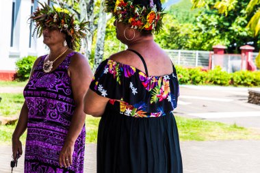 Moorea, Fransız Polinezyası: 09 / 03 / 2018: Güzel yerli kadınlar saçlarında çiçeklerle tipik elbiseleriyle konuşuyorlar. Tropikal Moorea Adası 'nda yaz günü.