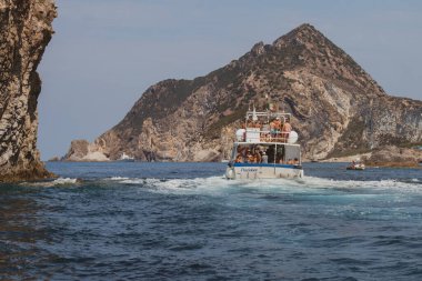 Ponza Adası, İtalya - 27 Temmuz 2019: İnsanlar tekneleriyle adanın mavi denizindeki uçurumlarda yüzüyor ve eğleniyorlar. Ponza, İtalya
