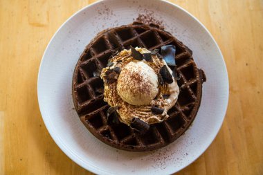 Üstünde vanilyalı dondurma olan çikolatalı waffle.