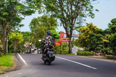 Sabahları Bali şehir merkezinde. Ana caddede hayat nehir etrafında, insanlarla ve renklerle dolu.