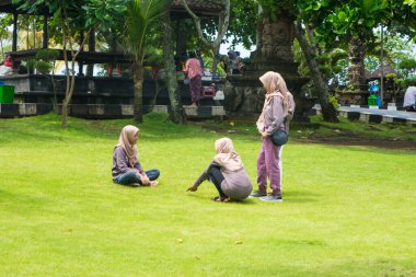İnsanlar, Endonezya 'nın en popüler tapınaklarından biri olan Bali' deki Tanah Lot su tapınağında boş zamanlarının tadını çıkarıyorlar. Tapınaklar yıl boyunca turistlerle dolu. Bali tapınakları Balines 'in fiziksel ve ruhsal alanına göre düzenlenmiştir.