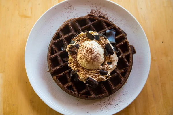 Üstünde vanilyalı dondurma olan çikolatalı waffle.