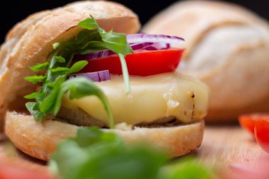 Sığır eti, soğan, domates, marul ve peynirli ev yapımı hamburger. Tahta kırsal masada taze sebzeli taze burger. Çizburger.