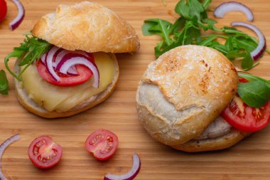 Sığır eti, soğan, domates, marul ve peynirli ev yapımı hamburger. Tahta kırsal masada taze sebzeli taze burger. Çizburger.