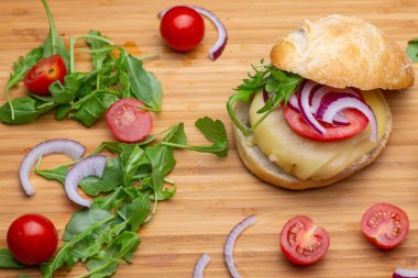 Sığır eti, soğan, domates, marul ve peynirli ev yapımı hamburger. Tahta kırsal masada taze sebzeli taze burger. Çizburger.