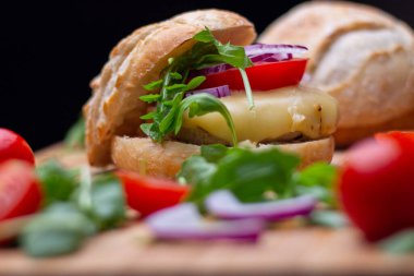 Sığır eti, soğan, domates, marul ve peynirli ev yapımı hamburger. Tahta kırsal masada taze sebzeli taze burger. Çizburger.