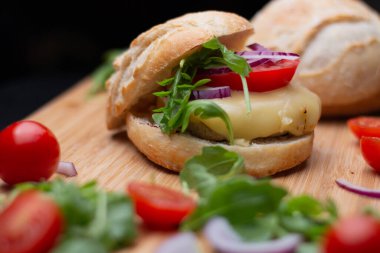 Sığır eti, soğan, domates, marul ve peynirli ev yapımı hamburger. Tahta kırsal masada taze sebzeli taze burger. Çizburger.