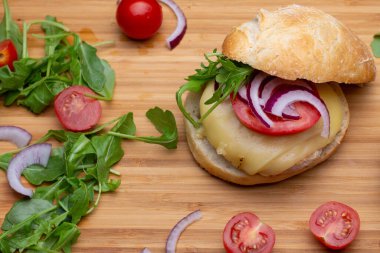Sığır eti, soğan, domates, marul ve peynirli ev yapımı hamburger. Tahta kırsal masada taze sebzeli taze burger. Çizburger.