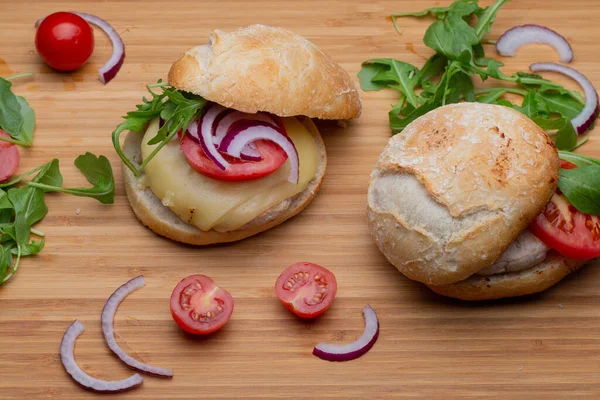Sığır eti, soğan, domates, marul ve peynirli ev yapımı hamburger. Tahta kırsal masada taze sebzeli taze burger. Çizburger.
