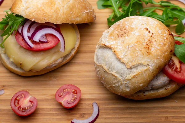 Sığır eti, soğan, domates, marul ve peynirli ev yapımı hamburger. Tahta kırsal masada taze sebzeli taze burger. Çizburger.