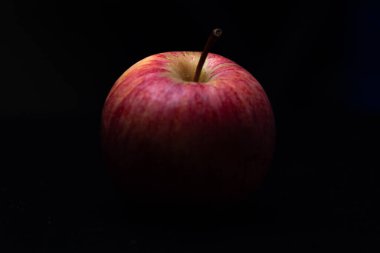 Siyah arka planda bir kırmızı taze elma. Sağlıklı meyve ve kahvaltı