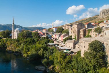 Bosna-Hersek 'teki Neretva nehri üzerindeki eski köprü, cami ve antik binalarla Mostar şehrinin güzel manzarası. Popüler turizm merkezi