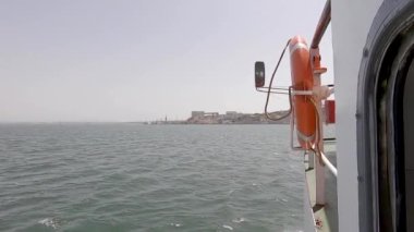 Portekiz 'de Lizbon' un merkezindeki Tagus Nehri 'nden geçen küçük bir turistik feribotun hava görüntüsü. Gün batımında Atlantik Okyanusu 'nda yüzen küçük bir geminin güzel hava manzarası. Arka planda mavi bir gökyüzü var.
