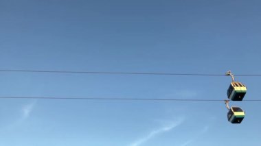 Gün batımında Lizbon 'daki Tagus nehri üzerinde uçan turistik teleferiğin 4K görüntüsü. Mavi gökyüzü arkaplanı dağınık bulutlar. Seyahat konsepti yaşam tarzı.