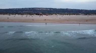 Costa de Caparica üzerindeki havadan kumsal manzarası. İnsansız hava aracı tarafından çekilen güzel manzara. Gün batımında Lizbon yakınlarındaki Portekiz sahili. Okyanus Görünümü.