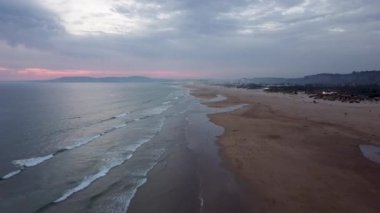 Costa de Caparica üzerindeki havadan kumsal manzarası. İnsansız hava aracı tarafından çekilen güzel manzara. Gün batımında Lizbon yakınlarındaki Portekiz sahili. Okyanus Görünümü.