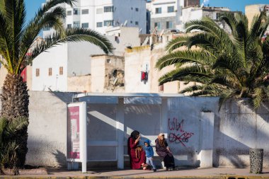 Casablanca, Fas: 09 / 07 / 2019: İnsanlar bir yaz günü Kazablanka şehir merkezindeki otobüs durağında konuşuyor ve bekliyor. Burası ıssız ve eski binalarla dolu. İnsanlar rahatlar.