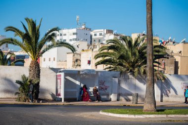 Casablanca, Fas: 09 / 07 / 2019: İnsanlar bir yaz günü Kazablanka şehir merkezindeki otobüs durağında konuşuyor ve bekliyor. Burası ıssız ve eski binalarla dolu. İnsanlar rahatlar.