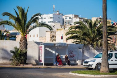 Casablanca, Fas: 09 / 07 / 2019: İnsanlar bir yaz günü Kazablanka şehir merkezindeki otobüs durağında konuşuyor ve bekliyor. Burası ıssız ve eski binalarla dolu. İnsanlar rahatlar.