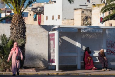 Casablanca, Fas: 09 / 07 / 2019: İnsanlar bir yaz günü Kazablanka şehir merkezindeki otobüs durağında konuşuyor ve bekliyor. Burası ıssız ve eski binalarla dolu. İnsanlar rahatlar.