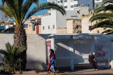 Casablanca, Fas: 09 / 07 / 2019: İnsanlar bir yaz günü Kazablanka şehir merkezindeki otobüs durağında konuşuyor ve bekliyor. Burası ıssız ve eski binalarla dolu. İnsanlar rahatlar.