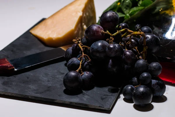 Beyaz arka planda az miktarda şarap, üzüm ve parmesan peyniri (italyan peyniri) içerir. Taze meyve ve peynir ve lezzetli bir İtalyan şarabı. Sağlıklı ve geleneksel İtalyan yemekleri..