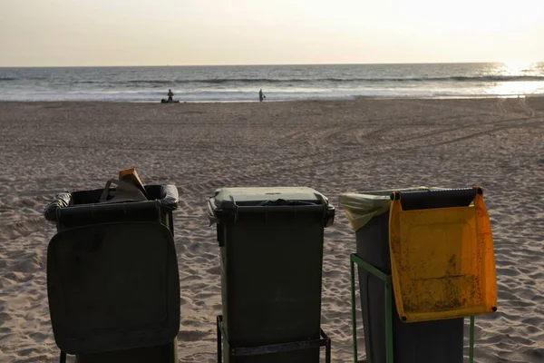 Isolated trash bins on the beach facing the Atlantic Ocean in Costa da Caparica in Lisbon. Environment concept lifestyle of waste management and recycling policy. Portugal, 2020