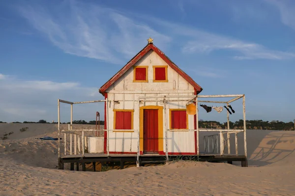 Beautiful characteristic wooden house along the beach side at Costa da Caparica in Lisbon, Portugal. Small village on the beach at sunset facing the Atlantic Ocean, abandoned building on the beach