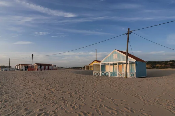 Beautiful characteristic wooden house along the beach side at Costa da Caparica in Lisbon, Portugal. Small village on the beach at sunset facing the Atlantic Ocean, abandoned building on the beach