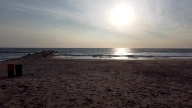 Costa da Caparica, Lizbon, Portekiz 'de Atlantik Okyanusu' nda günbatımının görüntüsü. Gün batımında kumsalın havası ve gün batımı.