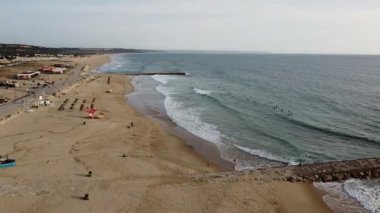 Costa da Caparica, Lizbon, Portekiz 'de Atlantik Okyanusu' nda günbatımının görüntüsü. Gün batımında kumsalın havası ve gün batımı.