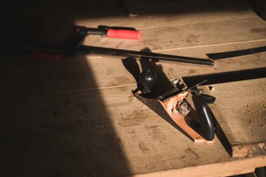 Küçük bir marangoz atölyesinin içindeki bir marangoz bürosu ahşap el yapımı aletleri gösteriyor. Marangozun çalışma masasında küçük bir tahta testeresi ve tornavida.