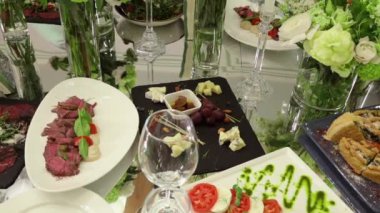 Festival masasındaki lezzetli atıştırmalıklar: peynir, üzüm, et madalyonu, domates.