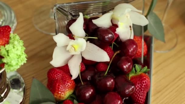 Kirschen Erdbeeren Und Orchideen Einer Glasvase Auf Dem Festtisch — Stockvideo