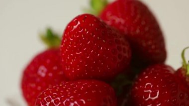 Beyaz arka planda dönen çileklerin yakın çekimi