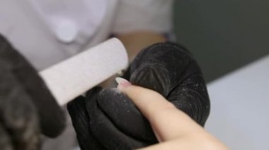 Profesyonel manikür. Çivi uzantısı. Tırnak dosyaları işleniyor.