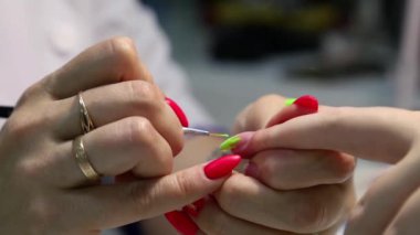 Profesyonel manikür. Çivi uzantısı. Tırnağına yeşil oje sür. Modern bir güzellik salonunda jöle tırnakları yapma prosedürü.