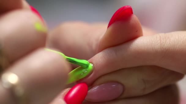专业的修指甲 指甲的伸展 涂上指甲油的主要绿色 在准备好的指甲油底上涂上一层薄刷 制作长人造凝胶钉的程序 — 图库视频影像