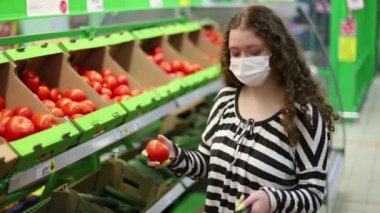 Süpermarketten alışveriş. Sosyal uzaklık. Halka açık yerleri ziyaret ederken kısıtlı güvenlik önlemleri. Salgın sırasında süpermarketten domates almak..