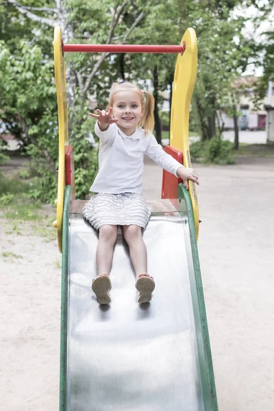 Girl drives off with children slides — Stock Photo, Image