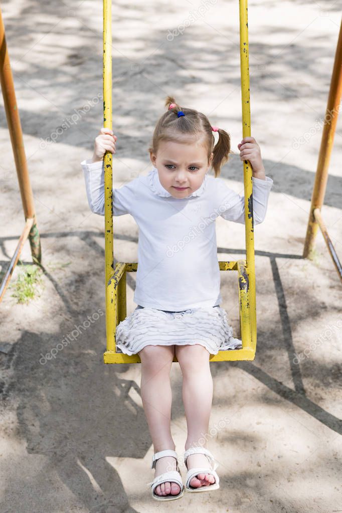 Serious girl on the swing