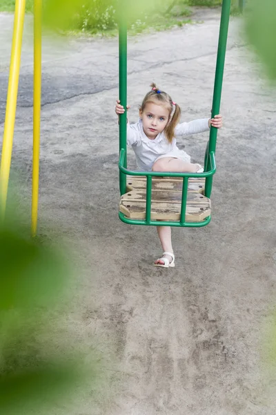 Girl climbs on a swing — Stock Photo, Image